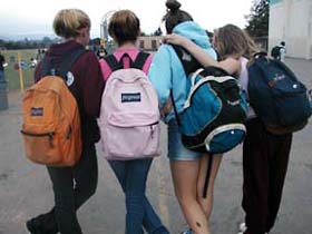 To avoid injury, children should carry their backpacks over both shoulders to balance the load.