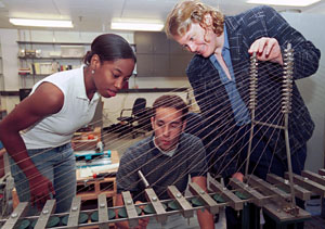 Ashley Lucas, a senior in civil engineering, and Diego Giraldo, a graduate student in civil engineering, examine a model bridge with their mentor, Shirley J. Dyke, Ph.D., associate professor of civil engineering.