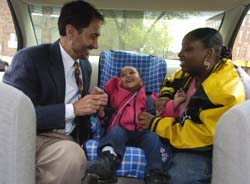 Randall S. Jotte, M.D., associate professor of medicine, explains to Tondra Holman how to properly restrain her 1-year-old daughter, Kenisha, in a car seat provided by the Safe and Secure program at the Grace Hill Soulard Neighborhood Health Center.