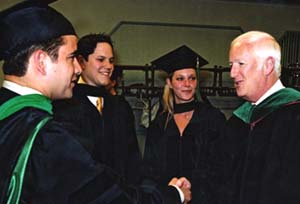 Larry J. Shapiro, M.D. (right), congratulates graduating medical students at Commencement last year.