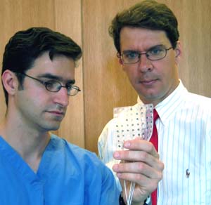 Eric C. Leuthardt, M.D. (left), a WUSTL neurosurgeon at Barnes-Jewish Hospital, and Daniel Moran, Ph.D., assistant professor of biomedical engineering in the School of Engineering & Applied Science, examine an electronic grid that is placed directly on the brain.