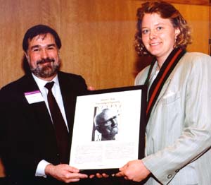 Christopher I. Byrnes, Ph.D., dean of the School of Engineering & Applied Science, presents a plaque to Shirley J. Dyke, Ph.D., at her installation as the Edward C. Dicke Professor of Engineering May 4.