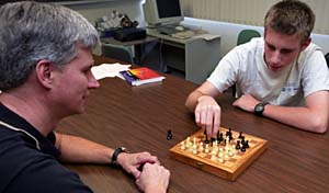 Steven Anderson (right) of Creve Coeur, Mo., a John Burroughs School senior, and Stan Kwasny, Ph.D., research associate in computer science and engineering, remove chess pieces to simulate a game called Arimaa, which is similar to chess but more difficult for a computer to beat. Kwasny worked with Anderson as his mentor in the STARS program for six weeks to help devise a computer program that can play a human in the game.