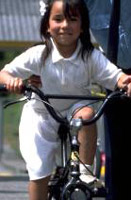 While this adorable little girl seems to be having a good time, she is also violating safe bicycling Rule # 1: always wear a helmet.