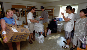Brittney Roetzel (left), resident assistant in Umrath Residence Hall, helps freshmen Yin Zheng (right, white shirt), from Bethesda, Md. and Taidghin O'Brien (in hat), from Philadelphia, get settled into their room during move-in day Aug. 26. Zheng's parents and O'Brien's father and brother lend a hand.