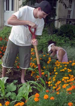 Freshmen David Israel and Camille Edelen work in the garden at Mullanphy Elementary School.
