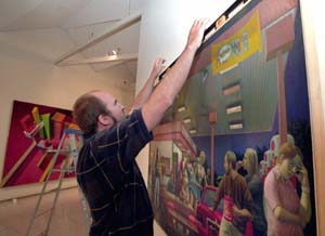 Robert McCann, lecturer in painting in the School of Art, installs his oil-on-panel *Gas!* (2003) in the Mildred Lane Kemper Art Museum as part of *The Washington University School of Art Faculty Show*, on view Sept. 30-Dec. 5.