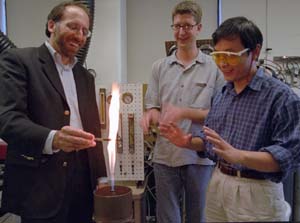 (From left) Richard L. Axelbaum, Ph.D., graduate student Ben Kumfer and postdoctoral researcher Sun Zhen, D.Sc., watch soot form on a pipette in Axelbaum's Urbauer Hall laboratory.