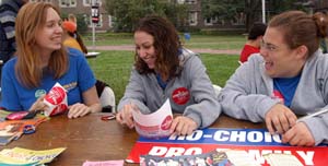 (From left) Kathryn Fahlund, Lisa Kohn and Annie Mehlman share a laugh while working the Students for Choice booth at the Rock the Vote event Oct. 9 in Brookings Quadrangle. The event aimed to educate and motivate voters to be more politically active.