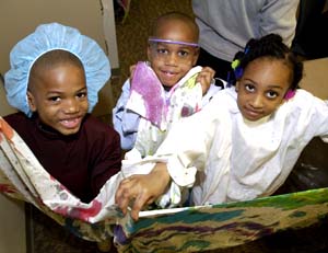 (From left) Sam, Dylan and Ashley Mopkins showcase the scarves they made for their mom, April Villars, at the Arts as Healing program at the Siteman Cancer Center March 21. 