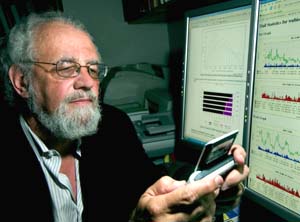 Biostatistics wizard Philip Miller checks e-mails on his Sidekick while simultaneously viewing system logs on his dual monitors. Miller explains that biostatistics keeps him connected to the latest computing technology at work and at home. 