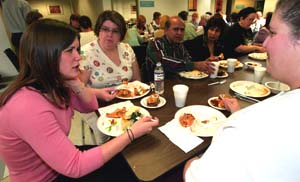 Teresa Sullivan (left) talks with immigrants during an ethnic potluck dinner at the International Institute in St. Louis. Sullivan was a development and communications intern at the institute, a refugee and immigrant transition organization.