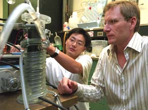 Lars Angenent (right) and doctoral student Jason He examine the upflow microbial fuel cell, which uses bacteria to treat wastewater and create electricity. Eventually, the device could handle the 2 million gallons of wastewater needed to create power for 900 homes.