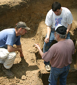 T.R. Kidder (seated in white shirt), professor of anthropology in Arts & Sciences, discusses the stratigraphy of Poverty Point's largest mound, Mound A, with Anthony Ortmann (left), graduate student at Tulane University, and Jon Gibson, professor of anthropology at the University of Louisiana at Lafayette.