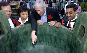 The Olin School of Business received a ding — part of a set of ceremonial bronze vessels — from E.M.B.A.-Shanghai program alumni to symbolize their strong ties with the University. Above, admiring the ding at its Sept. 30 dedication are (from left) Jackson Ling and Merry Zeng, both from the E.M.B.A. class that made the donation; Charles F. Knight, chairman emeritus of Emerson; and Mahendra Gupta, Ph.D., Olin School dean and the Geraldine J. and Robert L. Virgil Professor in Accounting and Management.