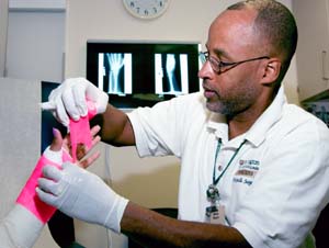 Cast technician Brian Rawls applies a cast to a patient with a wrist injury.