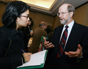 John F. McDonnell, vice chairman of the Board of Trustees, discusses the formation of the McDonnell International Scholars Academy with reporter I Ching Ng of *Ming Pao Monthly*, based in Albany, N.Y.