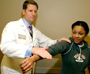 Matt Matava, M.D., checks the strength of Dominique Davis' shoulder three months after a right shoulder labial repair. Matava is the head team physician for the St. Louis Rams and provides orthopaedic services to the St. Louis Blues and WUSTL athletes. During the upcoming winter, he'll also serve as medical director for the U.S. Figure Skating Championships.