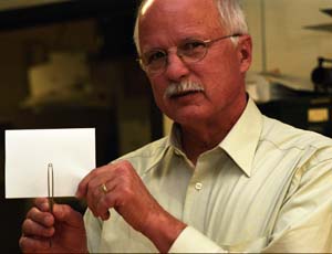 WUSTL Physicist James Schilling points out a tiny ceramic ring about the size of a small washer, key to a technique developed along with researchers at Argonne (Ill.) National Laboratory that could make superconductivity more practical.