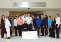 Employees from Brown Shoe Company and physicians and staff from the Siteman Cancer Center gather around Siteman Medical Director Timothy Eberlein, M.D. (center), Fashion Footwear of New York President Joseph Moore and Brown Shoe CEO Ron Fromm (seated L to R) during the check presentation May 24.