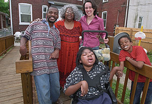 Cindy Traub (right, rear) helped organize a volunteer group that built a wheelchair ramp for Patricia Allen's sons, (from left) Patrick Pickett, Tony Allen and D.J. Allen. Lynn Bird of the University's Catholic Student Center says that if it hadn't been for Traub, the ramp project