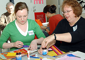 Maggie Young (left), a first-year medical student, and Karen Levine, a member of The OASIS Institute, work together to create two art pieces — one beautiful, one ugly — using any color except white.