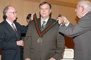 William P. Darby, Ph.D. (left), professor and vice dean of student affairs and associate dean of the School of Engineering & Applied Science, and James M. McKelvey, Ph.D., senior professor of chemical engineering and former dean of engineering, present Kevin Z. Truman, Ph.D., with a medallion at his recent installation as the Albert and Blanche Greensfelder Professor of Civil Engineering in the auditorium of Uncas A. Whitaker Hall for Biomedical Engineering.