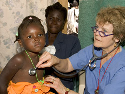 Patricia Wolff, M.D., examines a young patient in her pediatric clinic in Cap Haitien, Haiti, while the girl's mother looks on. Wolff's clinic is often the only medical care available to children in Cap Haitien.