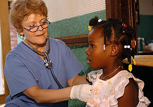 Patricia Wolff, M.D., gives a checkup to a girl in Meds & Food for Kids' (MFK) clinic in Haiti. MFK fights childhood malnutrition and related diseases in Cap Haitien, Haiti's second-largest city, by giving Ready-to-Use Therapeutic Food, a nutrient-rich mixture of peanuts, sugar, oil, vitamins, minerals and powdered milk, to children between 6 months and 5 years old with medically diagnosed malnutrition.