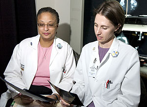 Dione Farria, M.D. (left), studies patient radiological images with resident Jennifer Demertzis, M.D.
