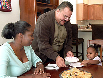 Luis Torres, Ph.D., postdoctoral fellow in the George Warren Brown School of Social Work, serves up snacks to his wife, Dernay Coley-Torres, and 2-year-old daughter, Gabrielle. The Torres family is new to the South 40.