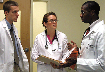 (From left) Theodore Armstrong, a pre-doctoral fellow, and Jourdan Stuart, a first-year medical student, discuss a patient they examined with Will R. Ross, M.D., faculty supervisor, assistant professor of medicine and associate dean for diversity, at the Saturday Neighborhood Health Clinic in the Forest Park Southeast neighborhood. School of Medicine students started the clinic to get Forest Park Southeast residents into the health-care system, as many don't have access to health care and are uninsured.