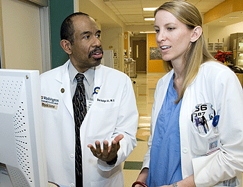 Dee Hodge III, M.D., shows third-year student Kristin Vanderploeg the new electronic records system used by the St. Louis Children's Hospital Emergency Department.