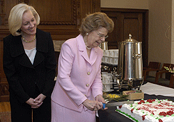 Kim Eberlein (left) watches Harriet K. Switzer, Ph.D., cut a cake presented to her at the Women's Society of Washington University's annual meeting April 11 in the Ann M. Olin Women's Building Formal Lounge. Switzer, who is retiring June 30, was feted for her more than 20 years as University coordinator of the society.
