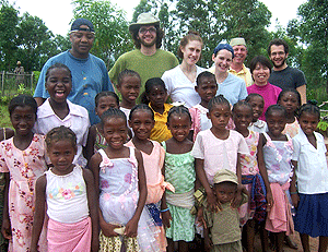 WUSTL representatives (from left) Kristopher Kelley (in green shirt), Kate Burson, Teresa Wallace, Ken Harrington, Yiping Chen and Russell Kohn pose with some children from Mahabo.