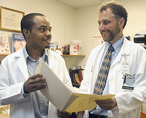 Kendrick Gwynn (left) talks with Jonathan M. Green, M.D., assistant professor of medicine and of pathology, at the Community Health-In-Partnership Services free clinic where Gwynn volunteers. Gwynn wasn't sure of his future plans until his junior year, when he decided to pursue a medical degree and a master of public health. He has been accepted to three programs and is deciding his plans for the fall.