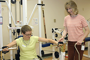 Kimberly A. Walker, OTD (right), works in the Enabling Mobility Center at Paraquad with patient Lindsay Ervin. Walker, a December 2006 graduate, has personal experience living with a mobility limitation, which taught her that assistive technologies can be the difference between participating in activities and being left out, says Walker's mentor David Gray, Ph.D.