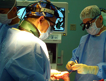 Jeffrey Lowell, M.D., (left) and Eric Shirley, lieutenant commander in the U.S. Navy, perform clubfoot repair surgery on a child while on board the USNS Comfort.