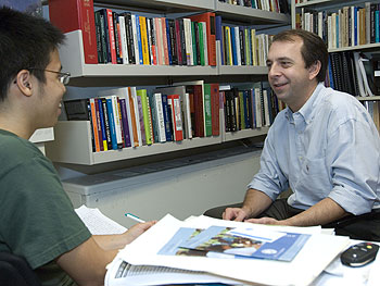 radley P. Stoner, M.D., Ph.D., associate professor of anthropology in Arts & Sciences and of medicine in the School of Medicine, chats in his office with Pornsak Chandanabhumma, a senior majoring in anthropology and biology, both in Arts & Sciences.