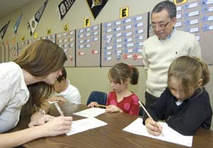 (Left to right)  Brooke Taylor, Kumon-Ladue assistant instructor and WUSTL Ph.D. student in English literature, first-grader Marley Hermann, Dan Kimura, senior professor of computer science and engineering and instructor at Kumon-Ladue and second-grader Samantha Hermann review math problems during a session at the  Kumon-Ladue math program on Clayton Road in Ladue. The Hermann girls are sisters.  Supplemental math programs, such as Kumon, Singapore and Saxon, are gaining popularity.  Kumon math has nearly 180,000 students enrolled in the United States and more than four million worldwide.