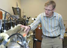 Lars Angenent, Ph.D., assistant professor of energy, environmental and chemical engineering, points to the mixed medium of thousands of organisms that help turn treated wastewater into electricity in this microbial fuel cell.