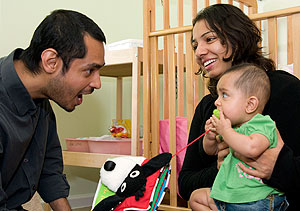 Asad Q. Ahmed, Ph.D., and his wife, Asma Kazmi, play with their six-month-old daughter, Marjaan al-Qadri, in the couple's apartment in Nemerov House in the South 40's Wayman Crow Residential College. Ahmed is one of three new faculty fellows this year.