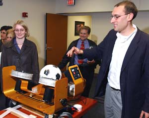 Guy M. Genin, Ph.D., assistant professor of mechanical engineering, shows a group of students and researchers an apparatus that monitors the impact of heading a soccer ball.