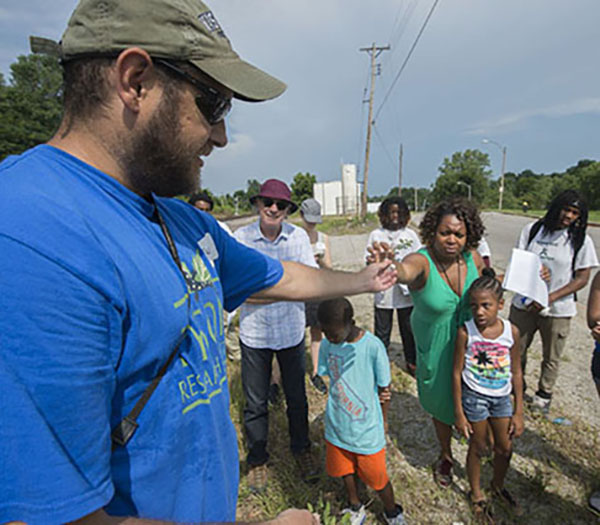 A group of people examining a dirt sample