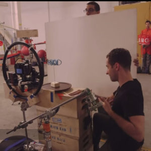 The camera man films a blue OK Go sign. When turned one side reads OK the other side reads Go.