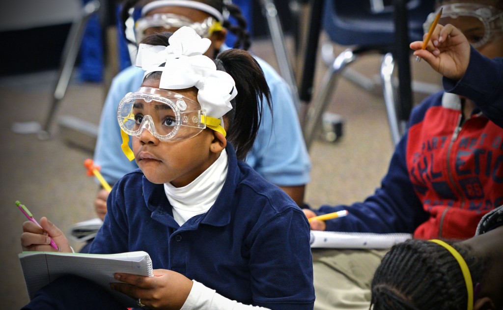 Fourth grader writing in lab notebook