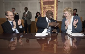 Three people applauding at a table