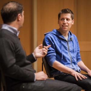 two men talk on stage