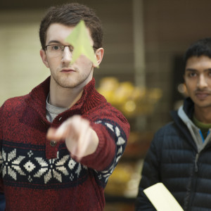 students throws paper airplane