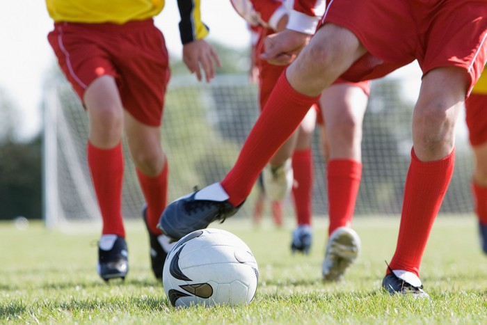 soccer players kicking a ball